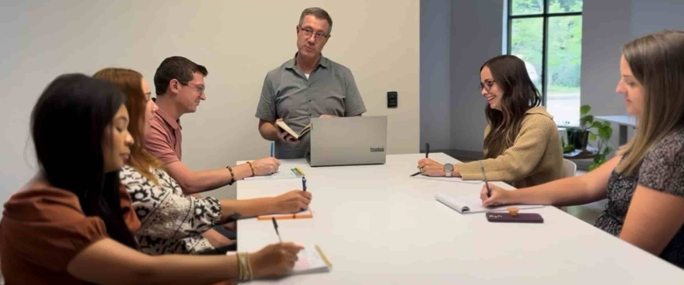 Team of recruiters huddled around table meeting