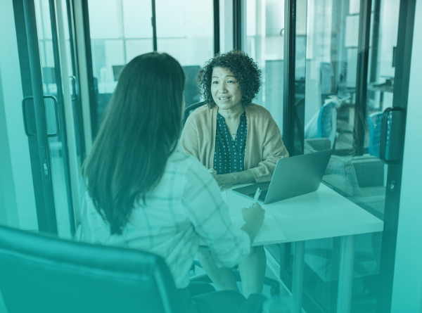 two women speaking at a desk